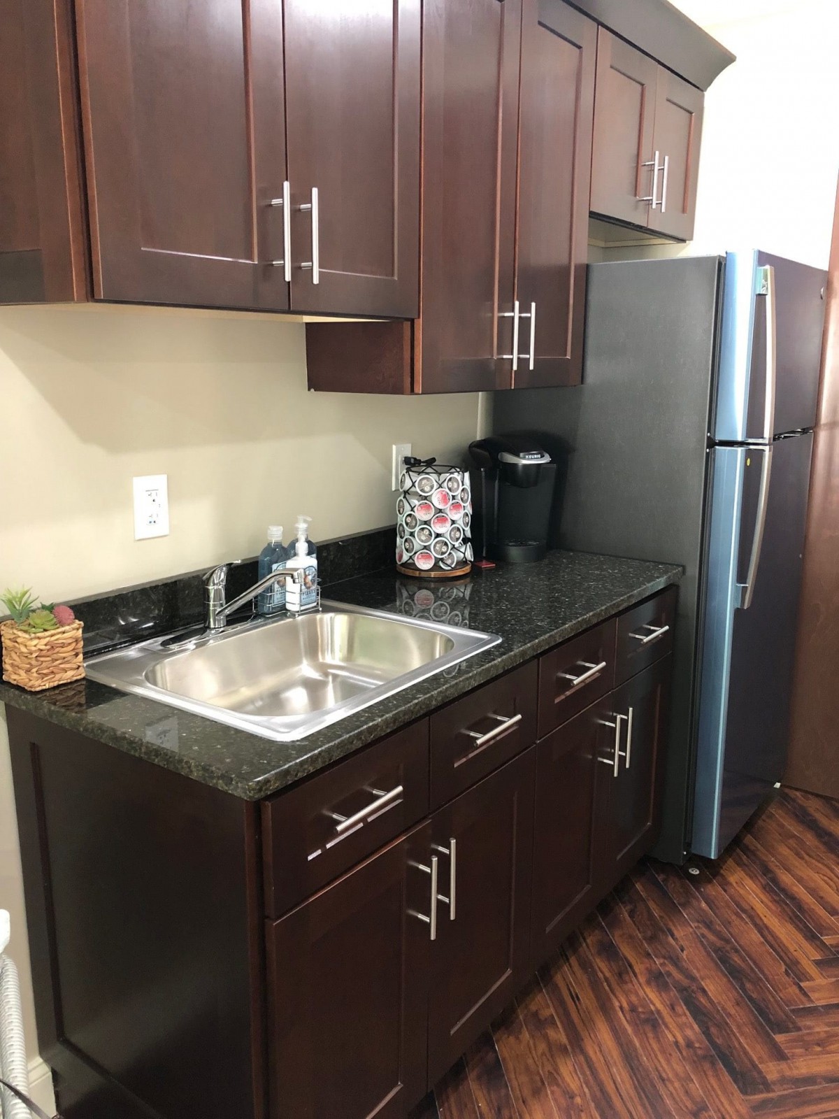 Modern kitchen with dark cabinets and stainless steel appliances.