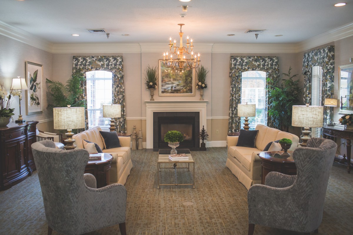 A cozy living room with elegant furnishings and a central fireplace.