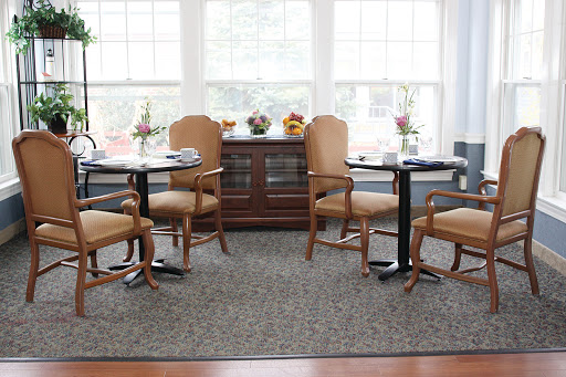 A cozy dining area featuring elegant wooden furniture, soft seating, and a bright atmosphere filled with natural light.