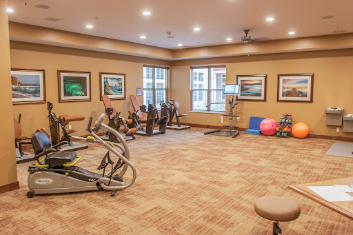 A well-equipped fitness center featuring various exercise machines and weights.
