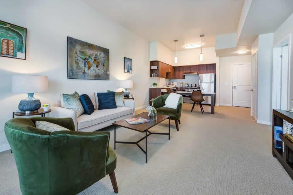 A modern open-concept living room and kitchen with stylish furniture and decorative artwork.