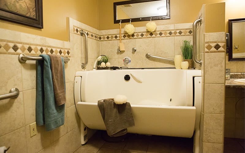 An accessible bathroom with a specialized bathtub, towels, and decorative elements.