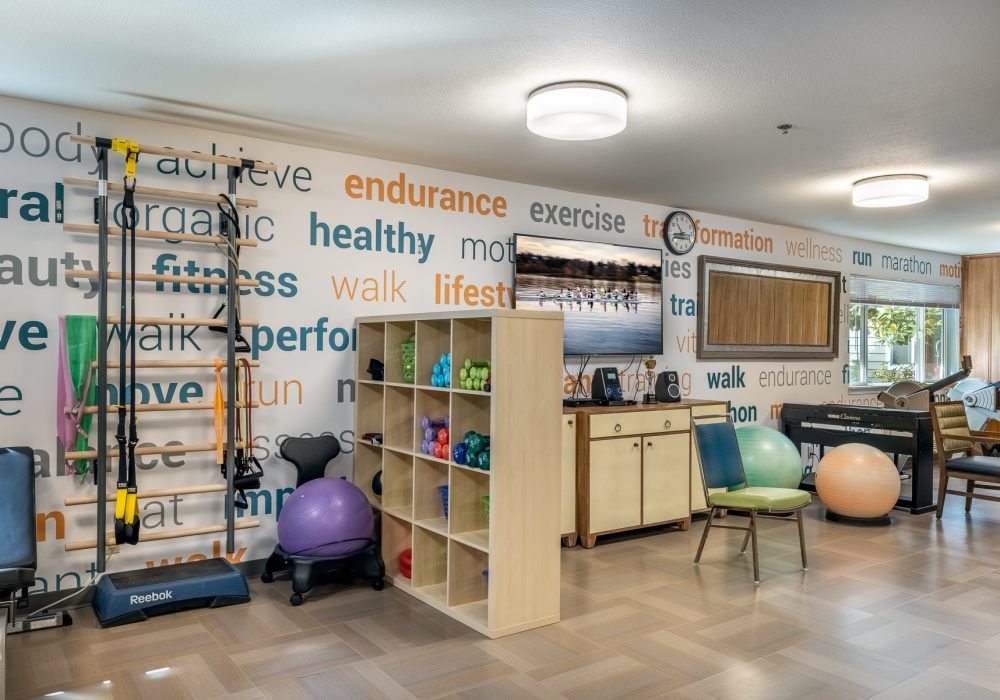 A wellness room featuring gym equipment, motivational words on the wall, and yoga balls.