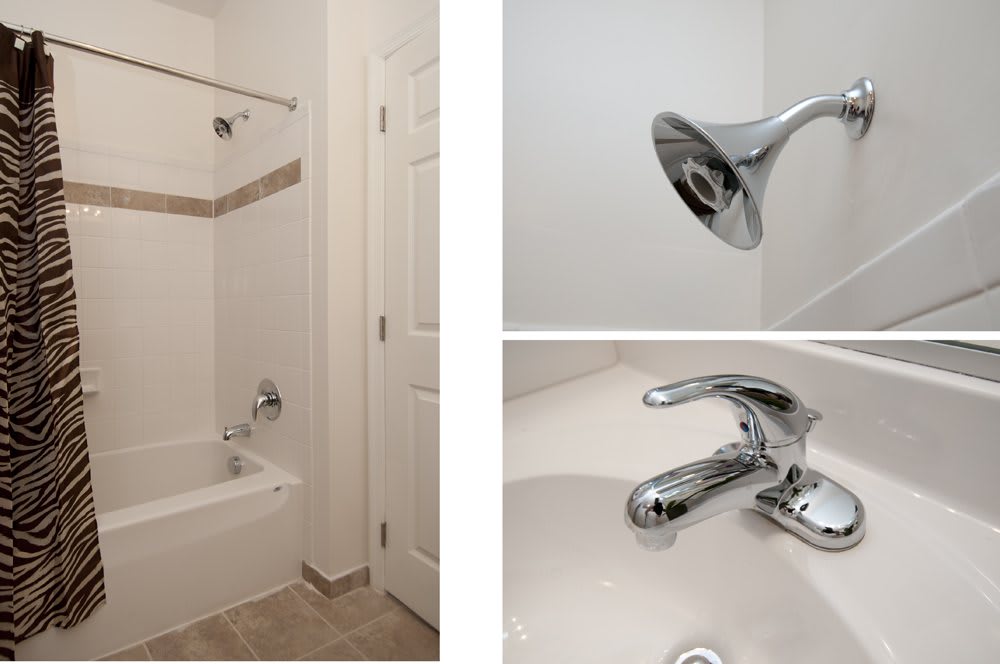 A modern bathroom featuring a bathtub with a shower, chrome faucet, and tiled floor.