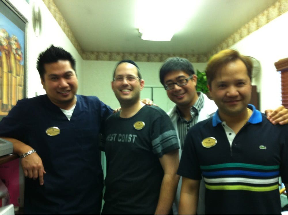 A group of four men smiling indoors.