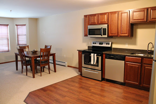 A cozy kitchen and dining area featuring modern appliances and wooden cabinetry.