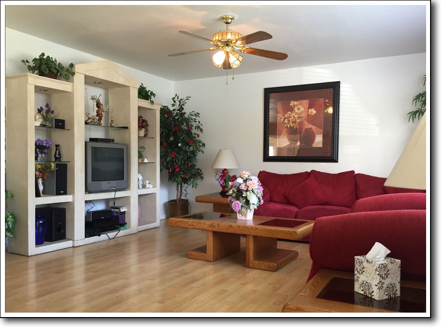 Cozy living room with a red couch and wooden furniture.