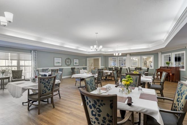 A well-decorated dining room with elegant furnishings and floral centerpieces.
