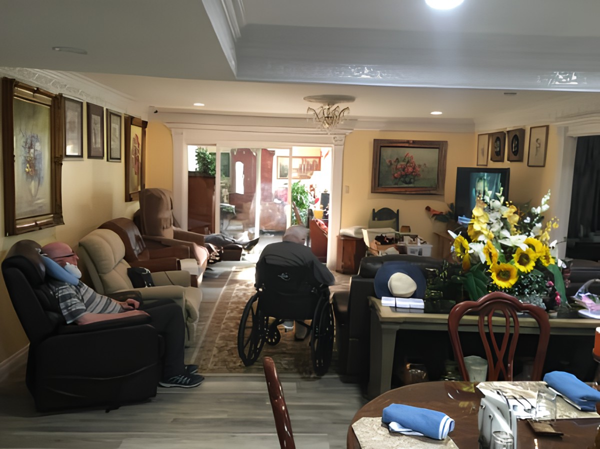A cozy living room with a wheelchair, television, and floral decorations.