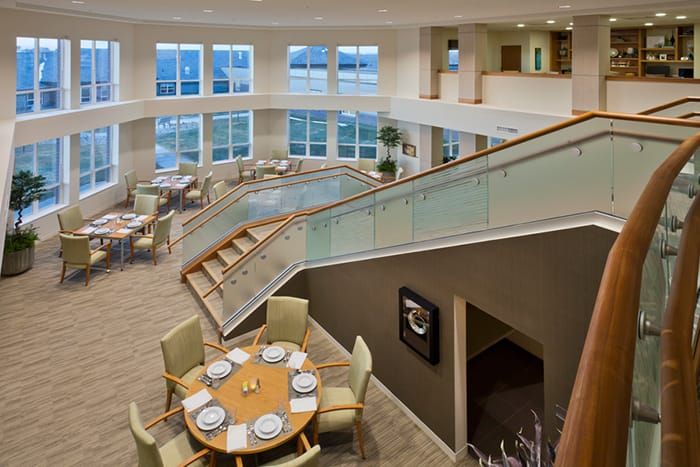 A modern interior with a spacious dining area and stylish staircase.