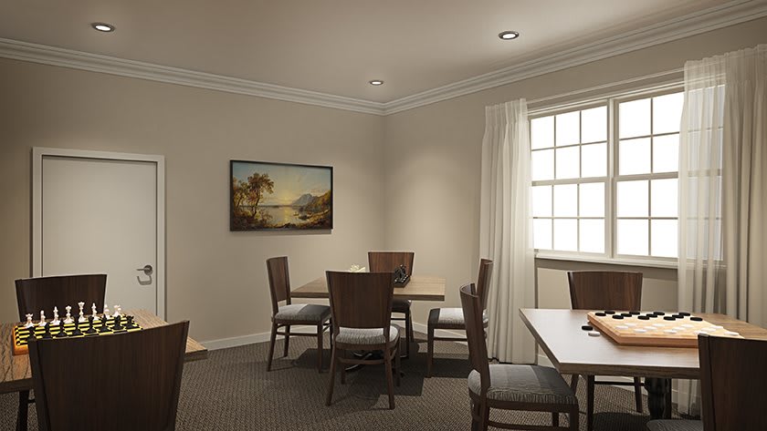 A cozy dining room with a table, chairs, and artwork on the wall.