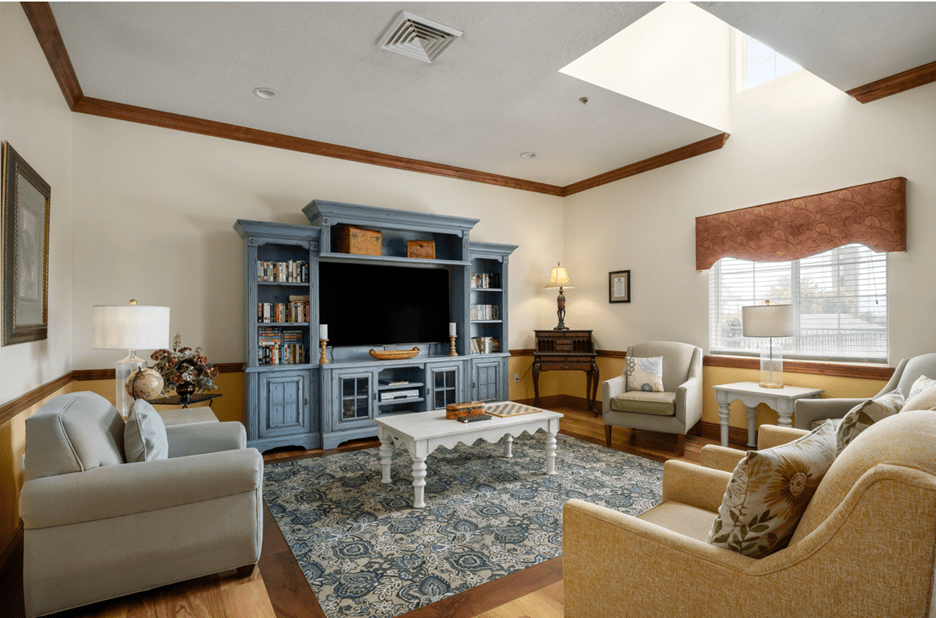 A cozy living room with a blue entertainment center, comfortable seating, and a patterned rug.