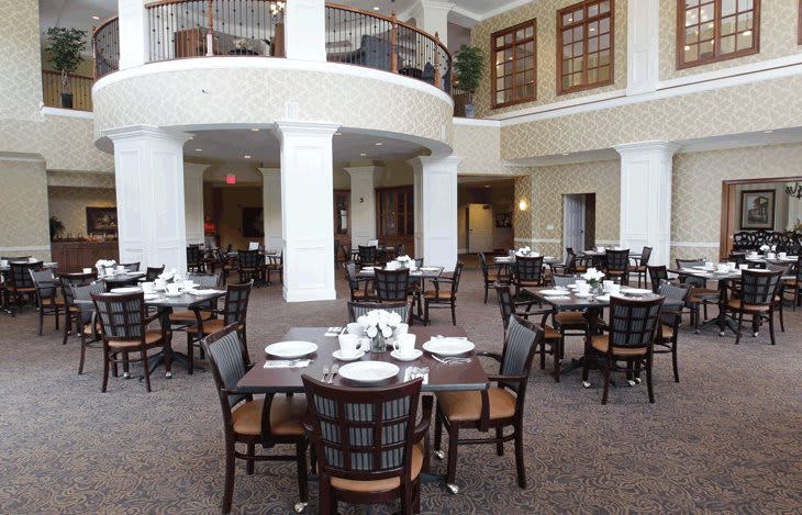 An elegant dining area with neatly arranged tables and chairs inside a spacious, well-lit room.
