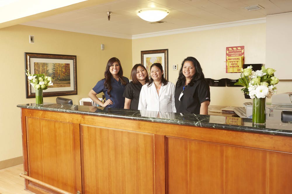 A group of hotel reception staff standing behind the front desk.