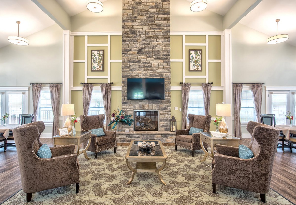 A cozy living room with a stone fireplace, comfortable seating, and elegant decor.