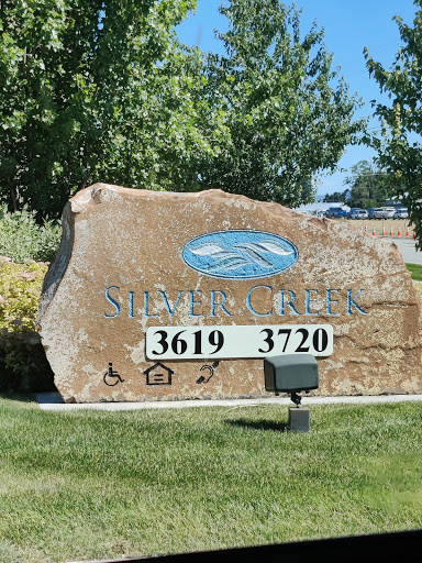 A stone sign displaying the addresses 3619 and 3720, located in a grassy area with trees in the background.