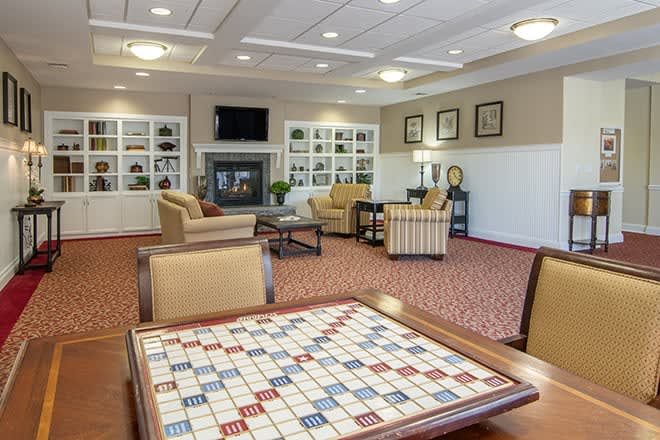 A cozy lounge area featuring comfortable seating and a game table.