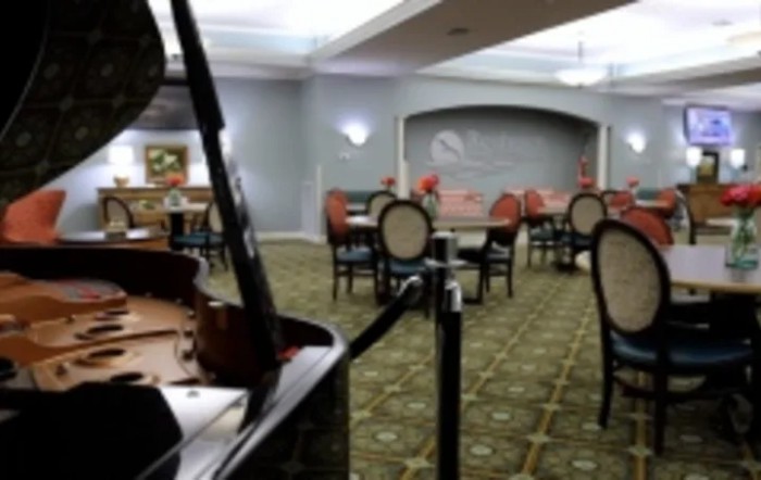 A cozy dining area with a grand piano and elegant seating arrangement.