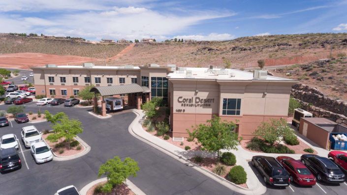A medical facility with a parking lot in a desert landscape.