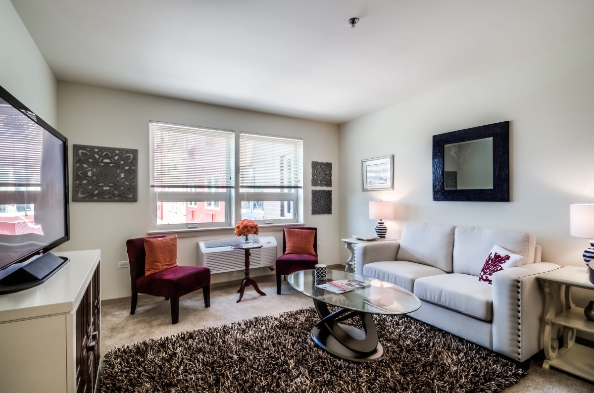 A modern living room with stylish furniture and decor, featuring a comfortable sofa, armchairs, and a glass coffee table.