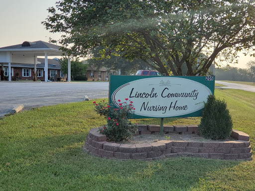 A sign indicating the Lincoln Community Nursing Home, surrounded by greenery.