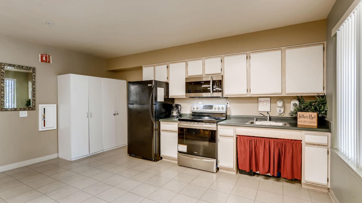 A modern kitchen featuring stainless steel appliances and white cabinets.