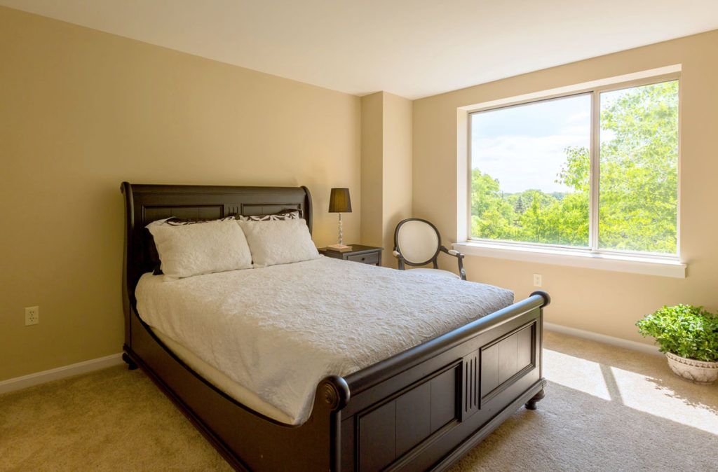 A cozy bedroom with a large window allowing natural light to fill the space.