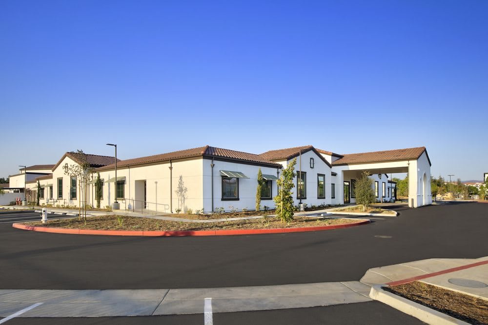A modern building with a driveway and clear blue sky.