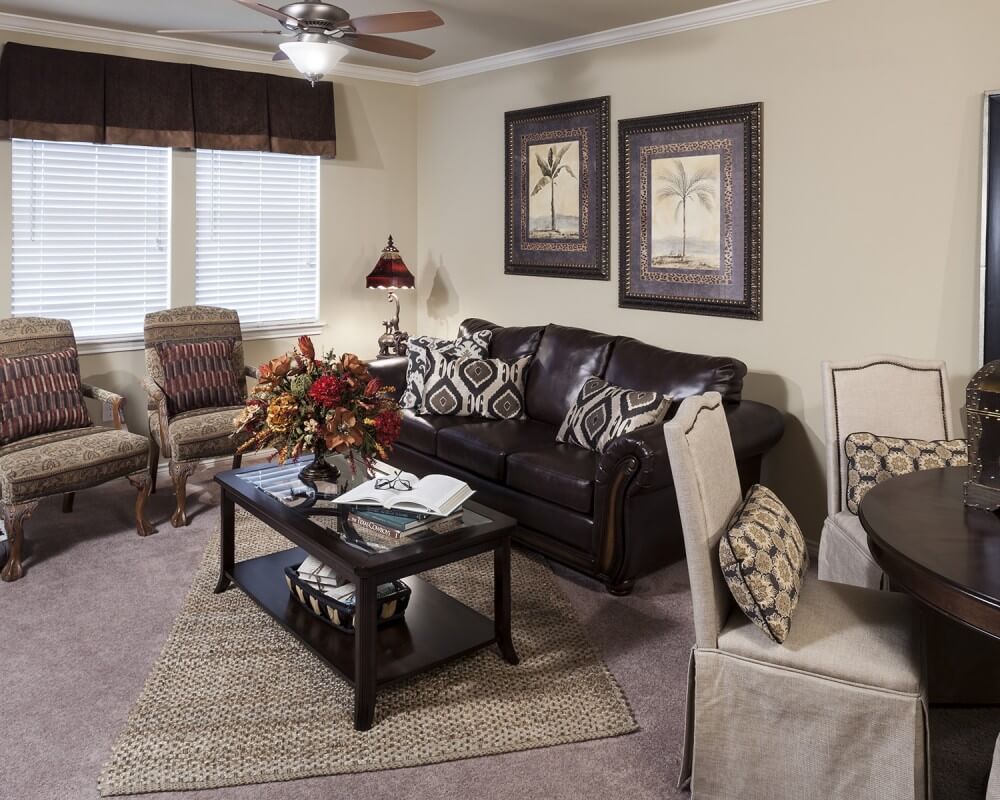 A cozy living room with a sofa, armchairs, and a coffee table adorned with decorations.