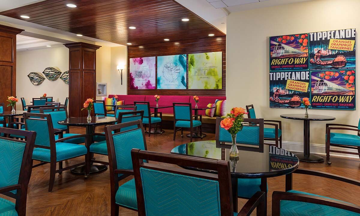 A vibrant dining area featuring colorful seating and modern artwork on the walls.