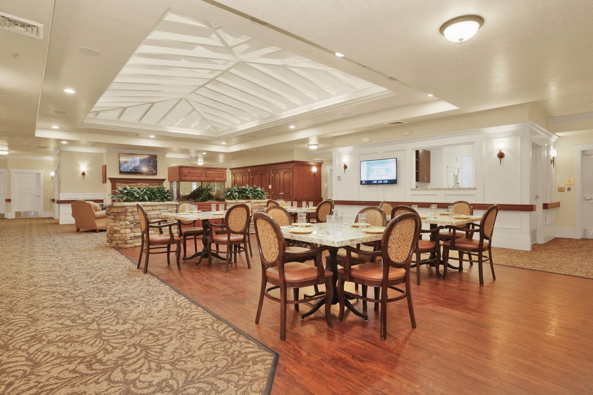 A spacious dining area with elegant furniture and a skylight ceiling.