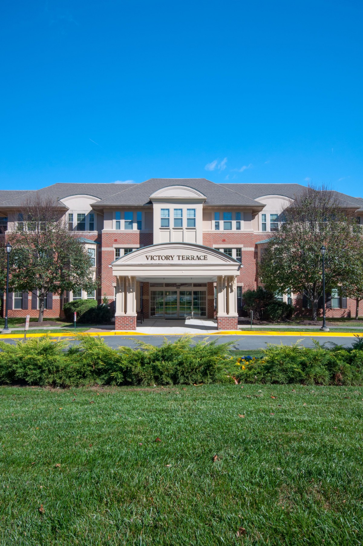 A well-maintained brick building with a welcoming entrance and landscaped surroundings.