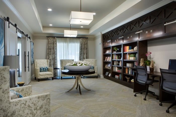 A modern library interior with bookshelves, a reading area, and stylish furniture.