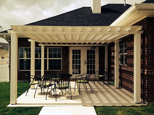 A backyard patio with a pergola providing shade, featuring outdoor furniture for relaxation.