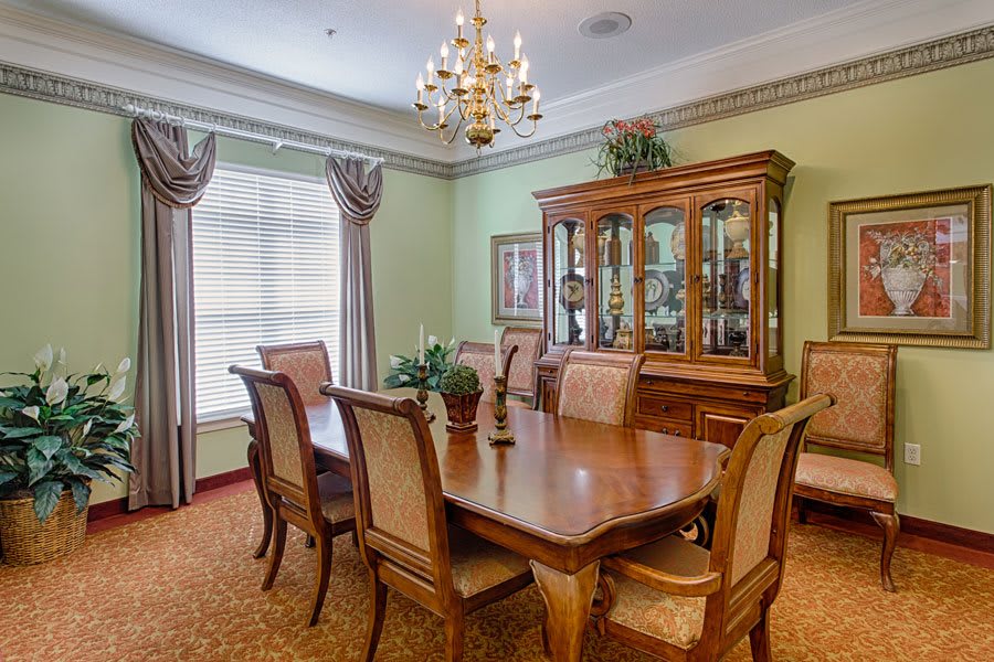 A classic dining room with wooden furniture and a chandelier.