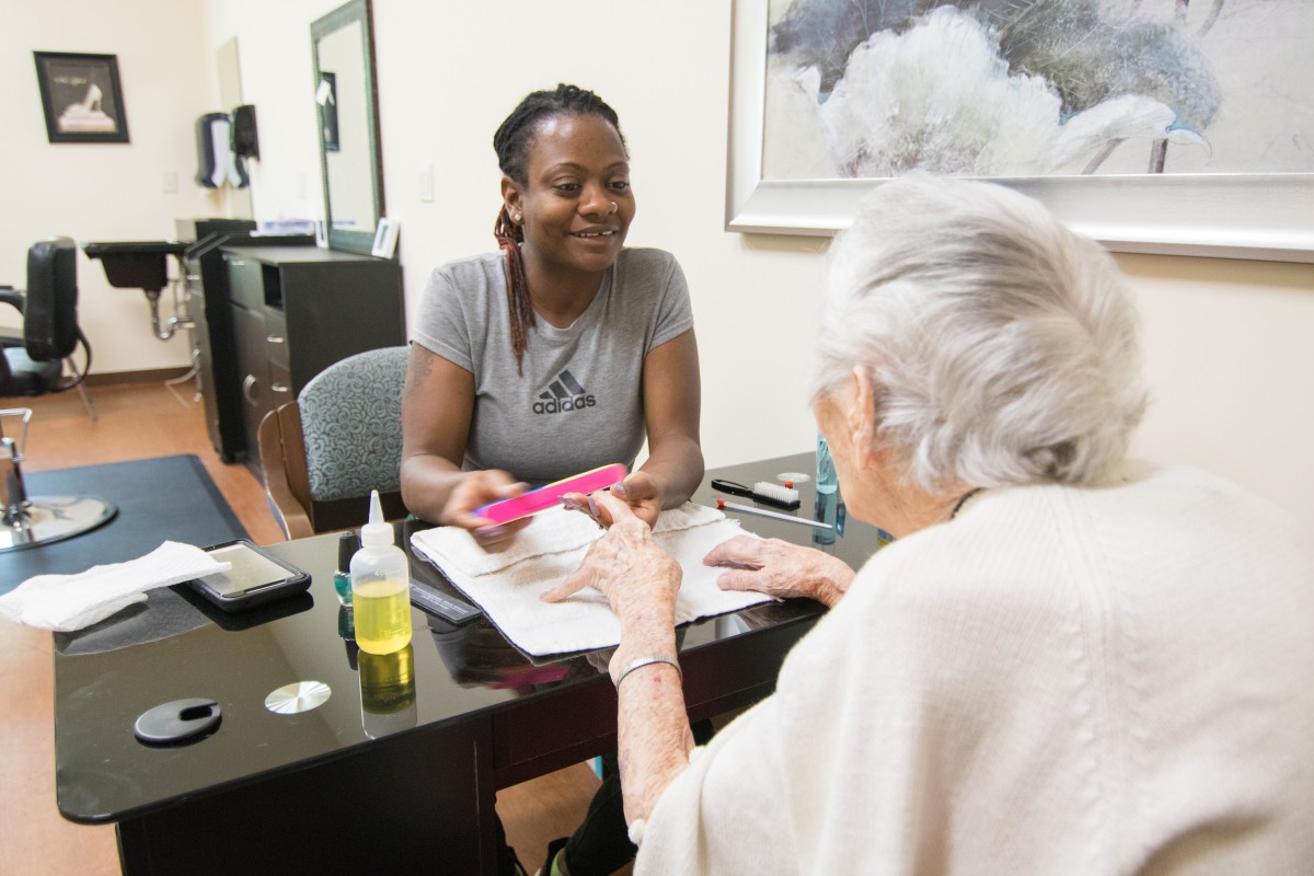 A person receives a manicure at a nail salon, showcasing personal care and interaction.