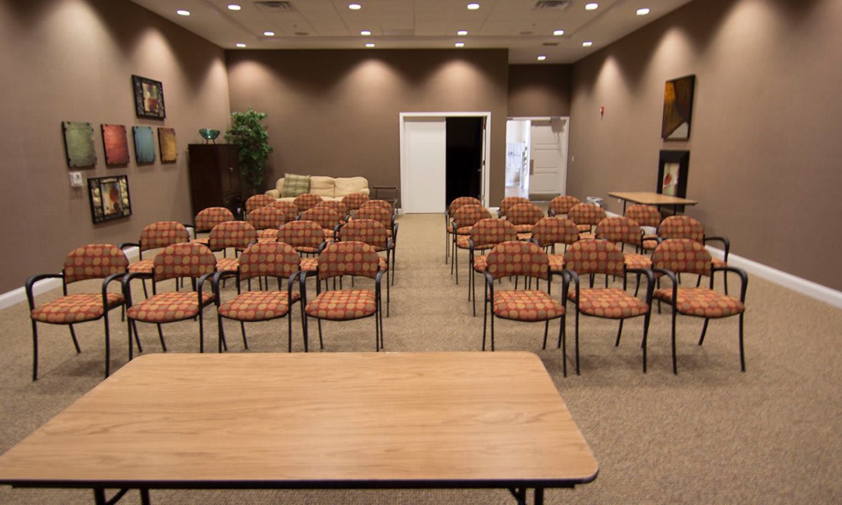 A conference room setup with rows of chairs facing a table.