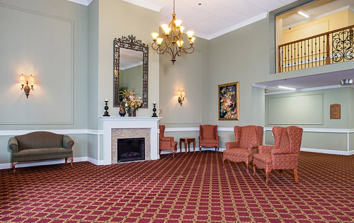 A cozy lobby with elegant furnishings and a chandelier.