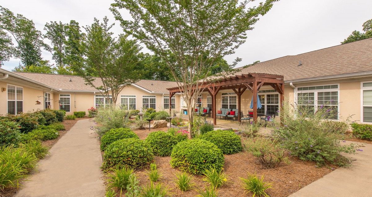 A well-landscaped garden with a patio in front of a building.