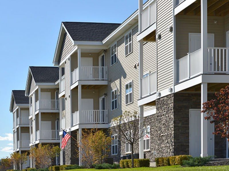A modern apartment building with balconies and landscaped surroundings.