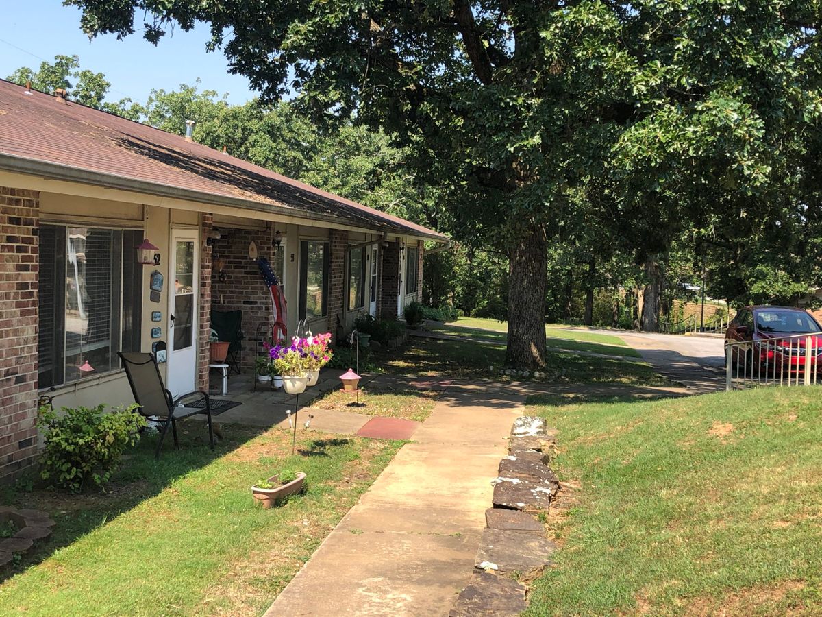 A suburban house with a front yard and sidewalk on a sunny day.