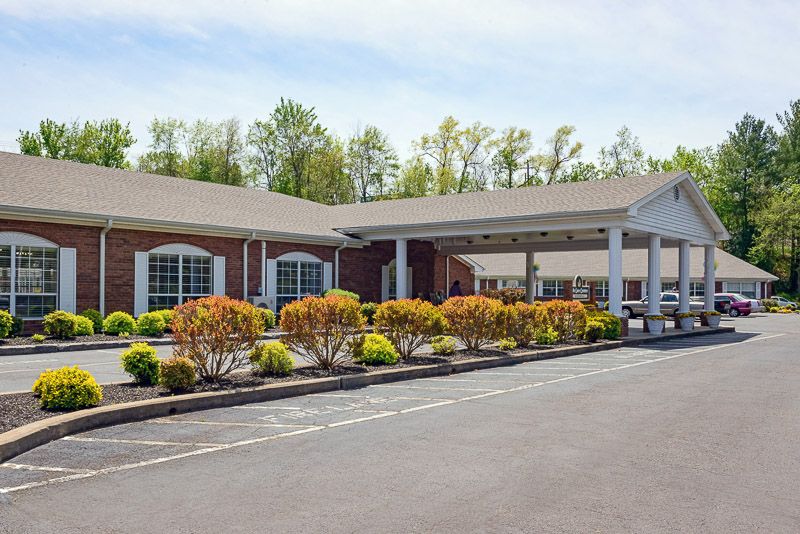 A well-maintained hotel building with a landscaped entrance and parking area.