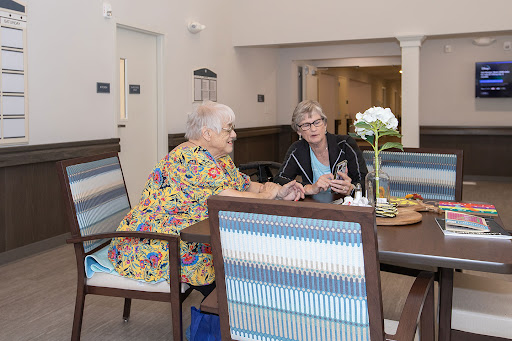 Two seniors enjoying a lively conversation in a cozy community space.