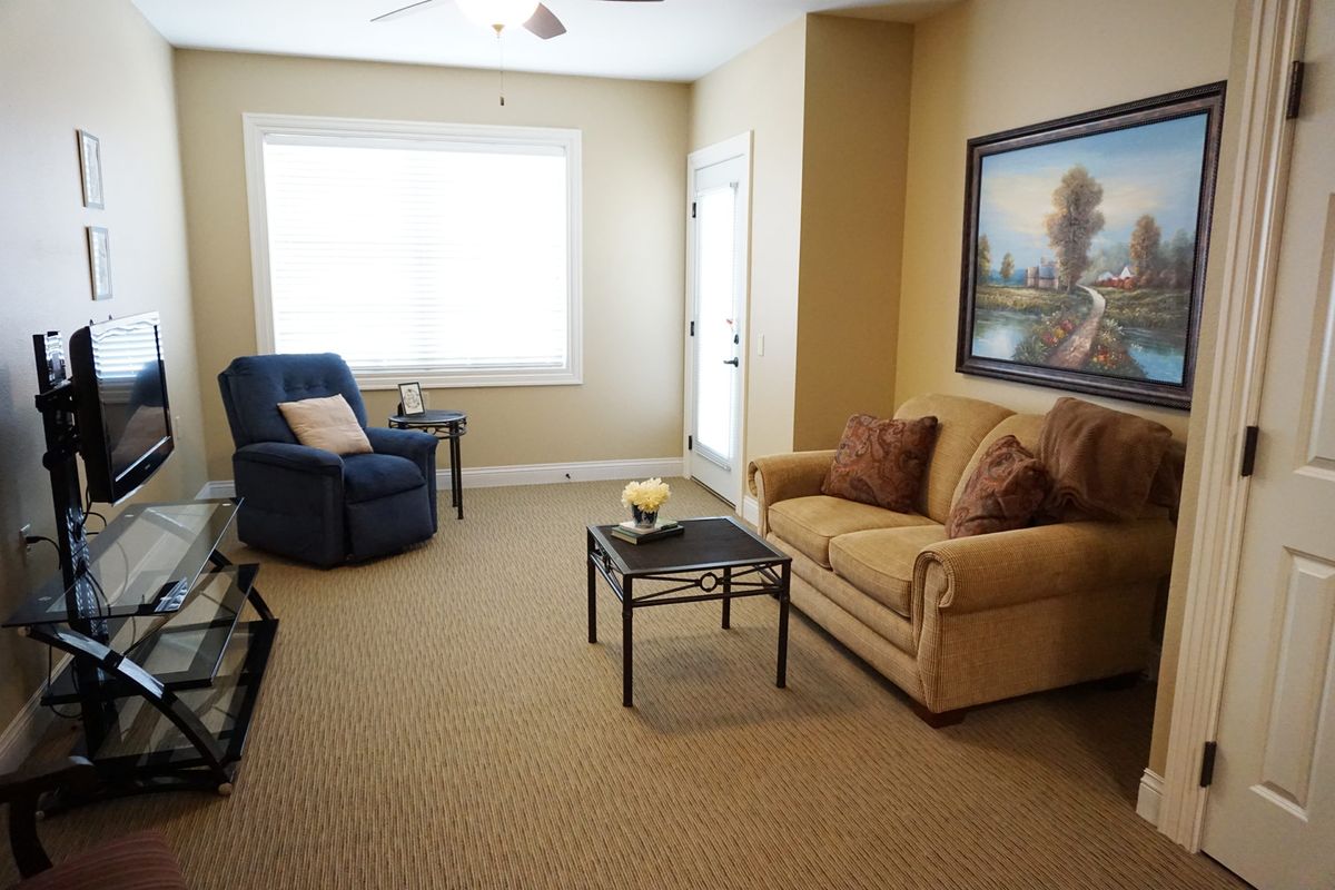 A cozy living room featuring a couch, armchair, and coffee table.