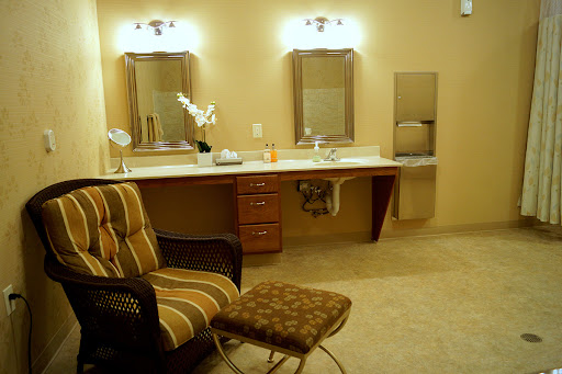 A well-designed bathroom featuring a vanity area with two mirrors and comfortable seating.