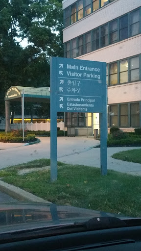 Signage indicating the main entrance and visitor parking area.