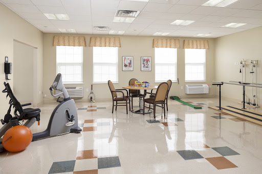 A spacious rehabilitation room with exercise equipment and a cozy seating area.
