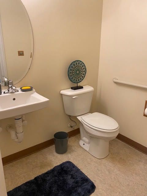 A clean bathroom with a sink, toilet, and decor.