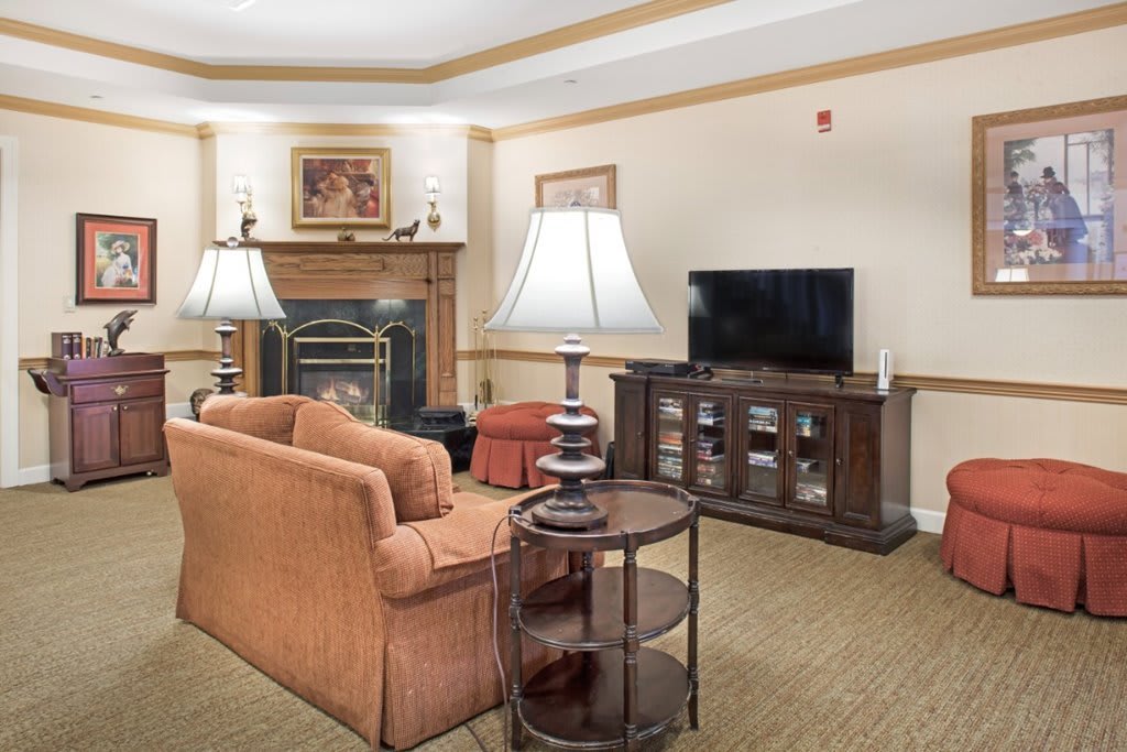 A cozy living room with a sofa, television, and fireplace.