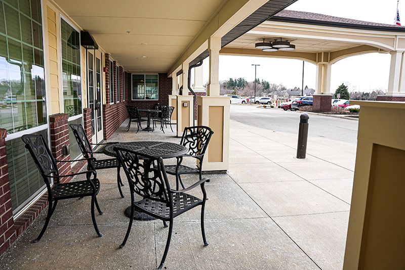 Empty outdoor seating area in a shopping center with metal tables and chairs.